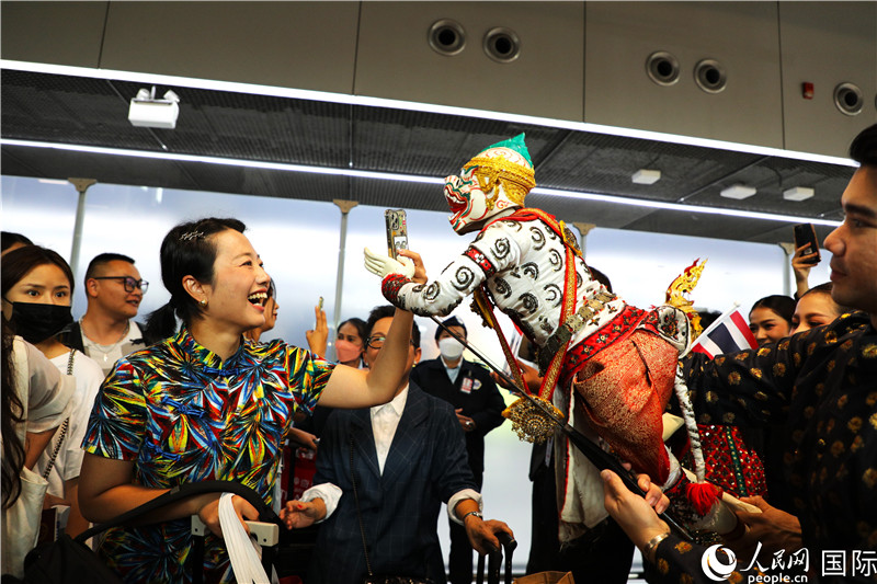 在迎接儀式中，泰國機(jī)場工作人員與中國游客友好互動。人民網(wǎng)記者 白元琪攝。