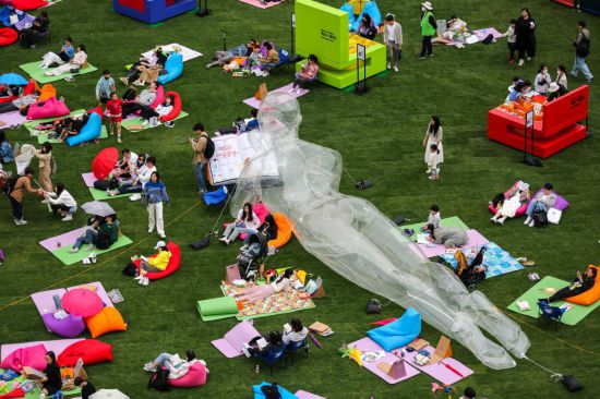 2023年4月23日，人們?cè)陧n國(guó)首爾廣場(chǎng)上閱讀和休息。新華社記者王益亮攝